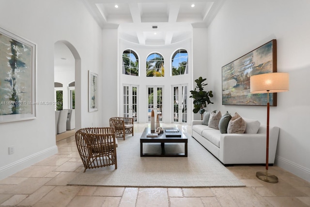 living room with french doors, coffered ceiling, a towering ceiling, and beamed ceiling