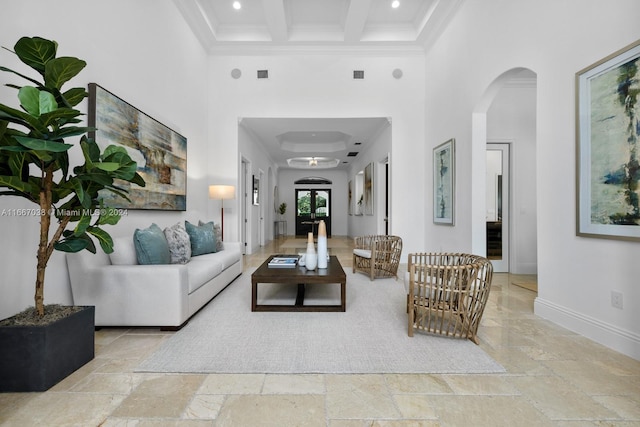 living room with beam ceiling, ornamental molding, and a high ceiling