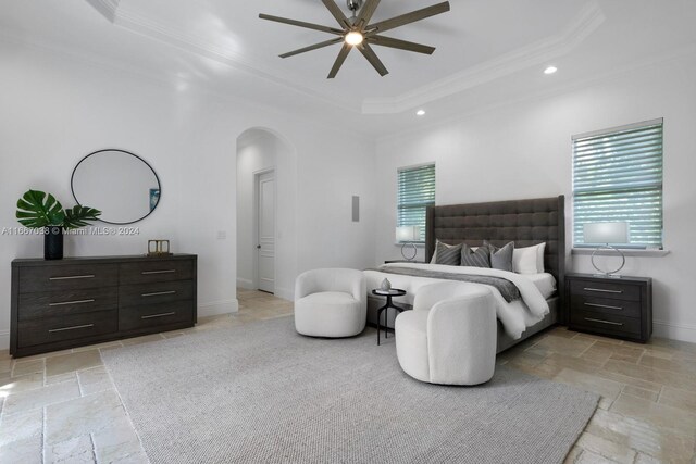 bedroom with ceiling fan, ornamental molding, and a tray ceiling