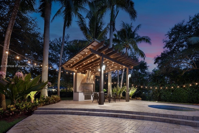 view of home's community featuring a pergola, a patio area, a hot tub, and an outdoor kitchen