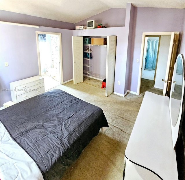 carpeted bedroom with lofted ceiling and a closet