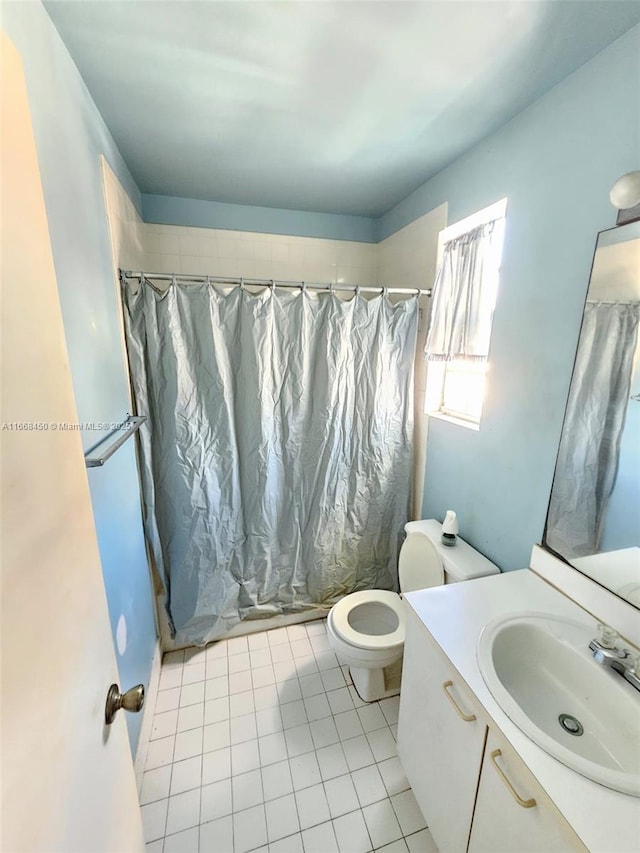 bathroom featuring tile patterned flooring, vanity, walk in shower, and toilet