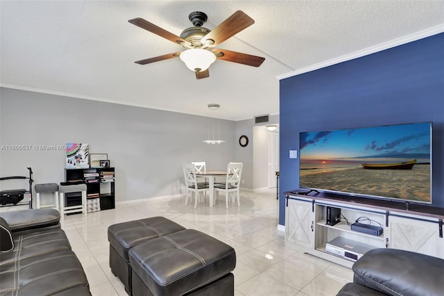 living room featuring ornamental molding, ceiling fan, light tile patterned floors, and a textured ceiling