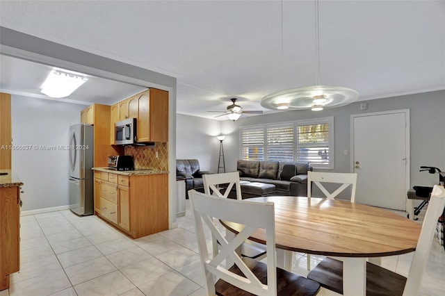 dining area with light tile patterned floors, crown molding, and ceiling fan