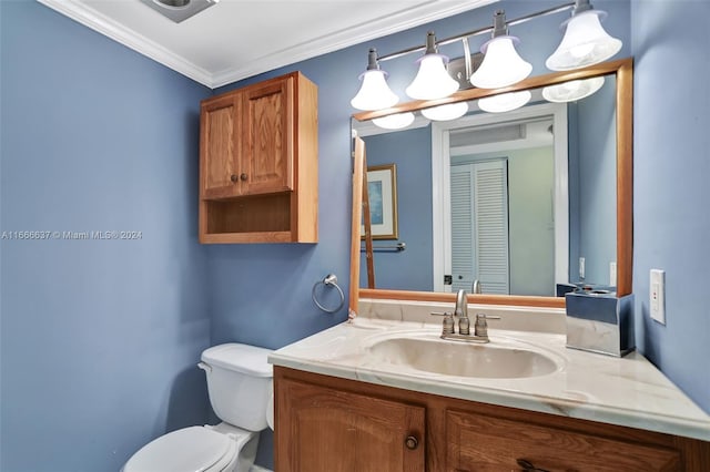 bathroom featuring vanity, crown molding, and toilet