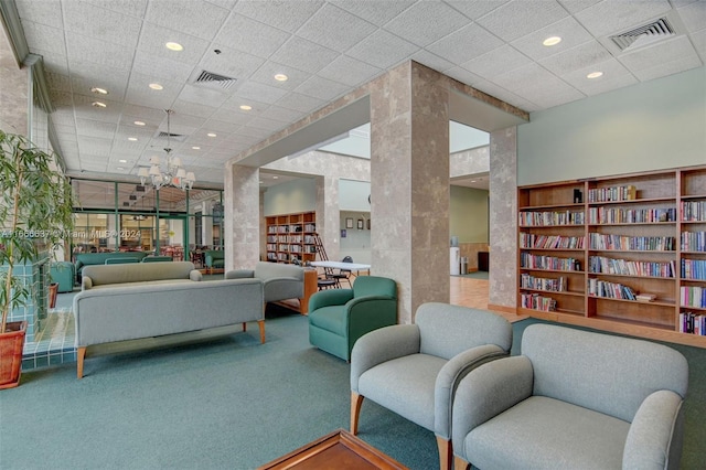 carpeted living room with an inviting chandelier and a paneled ceiling