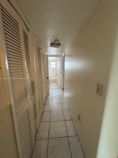 hallway featuring light tile patterned floors