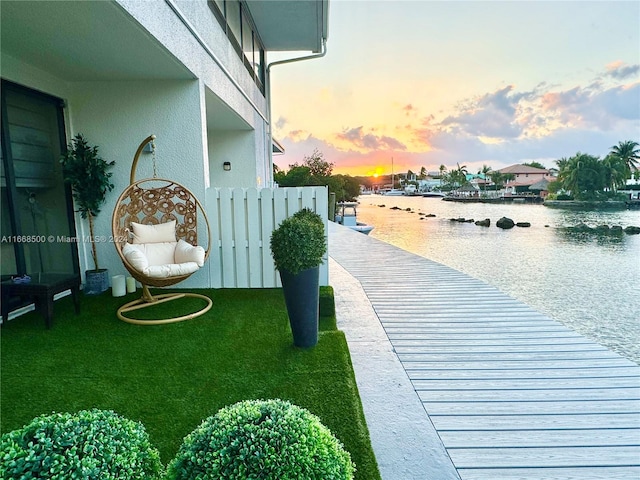 dock area featuring a lawn and a water view