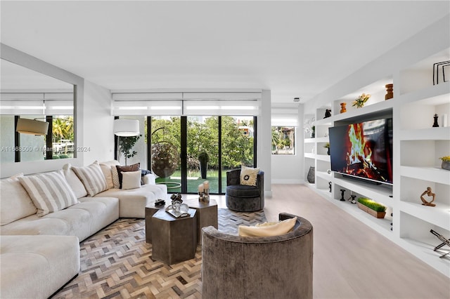 living room with built in shelves and light parquet floors