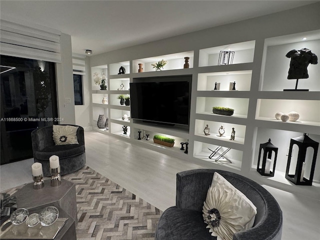 living room featuring light hardwood / wood-style floors and built in shelves