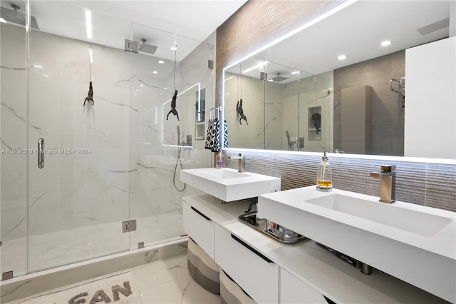 bathroom featuring a shower with door, vanity, and tile walls