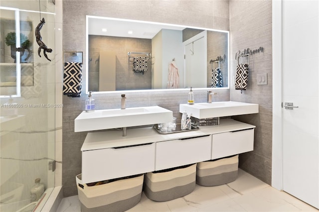 bathroom with vanity, tile walls, and a shower with shower door