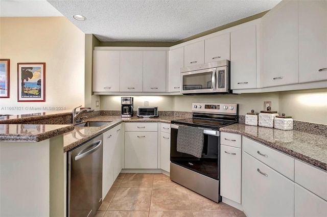 kitchen featuring white cabinets, sink, appliances with stainless steel finishes, and a textured ceiling