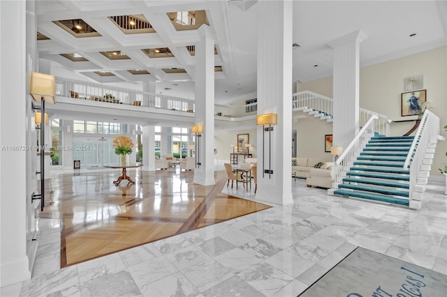 foyer entrance featuring beamed ceiling, a towering ceiling, ornamental molding, and coffered ceiling