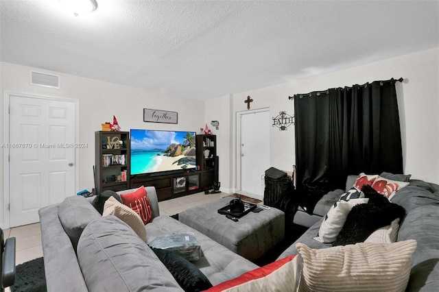 living room with a textured ceiling and light tile patterned floors