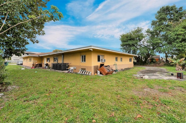 view of side of home with a yard, a patio, and central AC