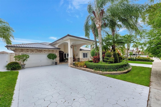 mediterranean / spanish-style house featuring a front yard and a garage