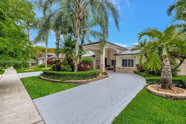 mediterranean / spanish-style house featuring a front lawn