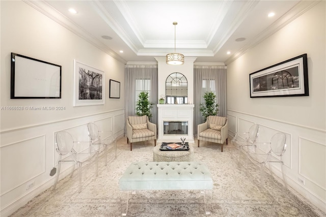 sitting room with a tray ceiling and crown molding