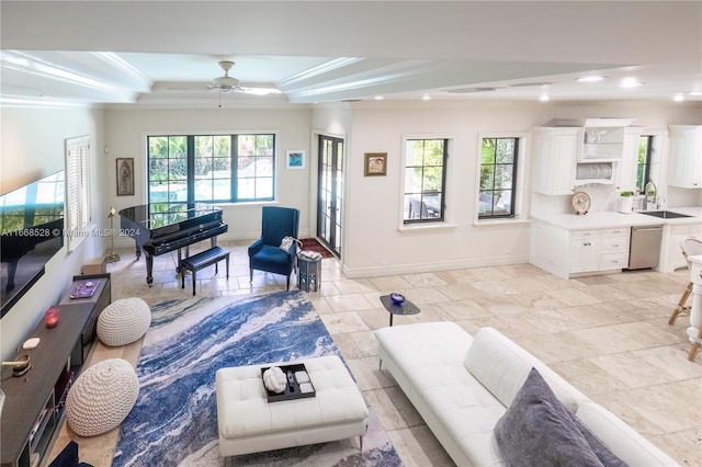 living room with crown molding, sink, ceiling fan, and plenty of natural light