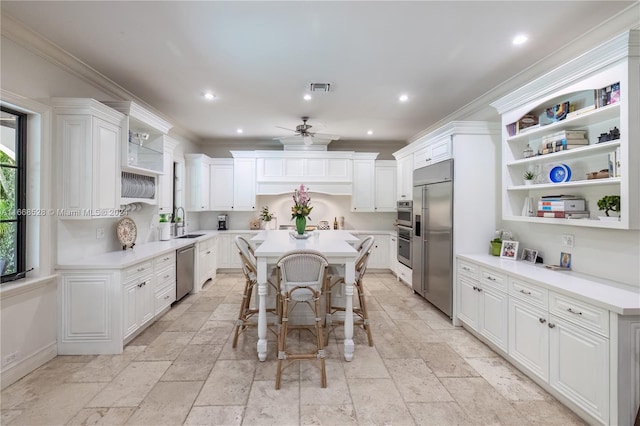 kitchen featuring a kitchen breakfast bar, ornamental molding, white cabinetry, and a center island