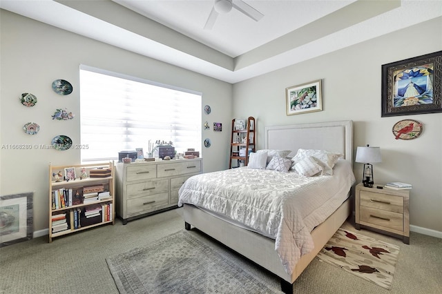 bedroom featuring ceiling fan, a raised ceiling, and carpet floors