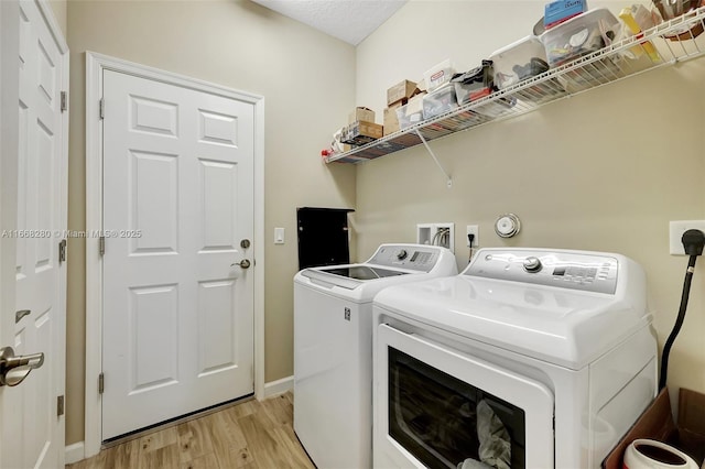 laundry room featuring independent washer and dryer and light wood-type flooring