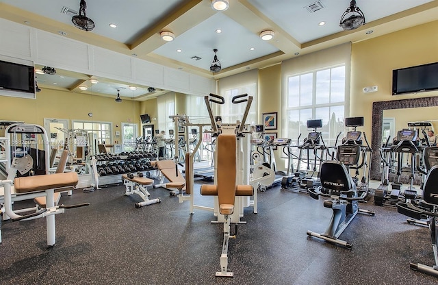 gym with a healthy amount of sunlight and a towering ceiling