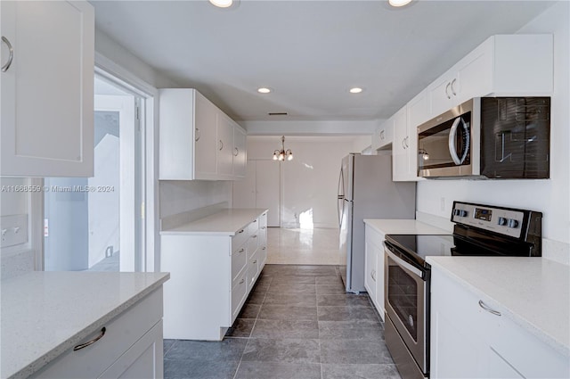 kitchen with decorative light fixtures, an inviting chandelier, stainless steel appliances, and white cabinetry