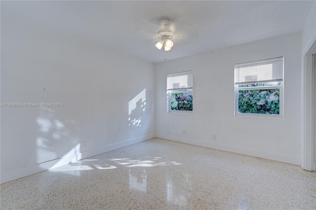 spare room featuring plenty of natural light and ceiling fan