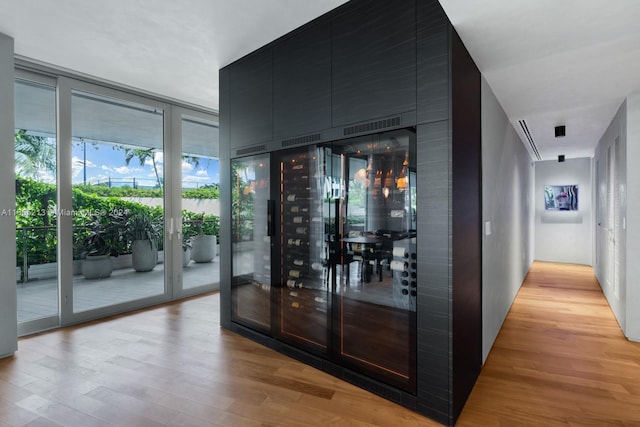 wine room with a wall of windows and light hardwood / wood-style flooring