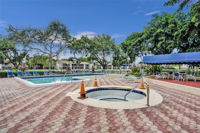 view of swimming pool featuring a hot tub and a patio