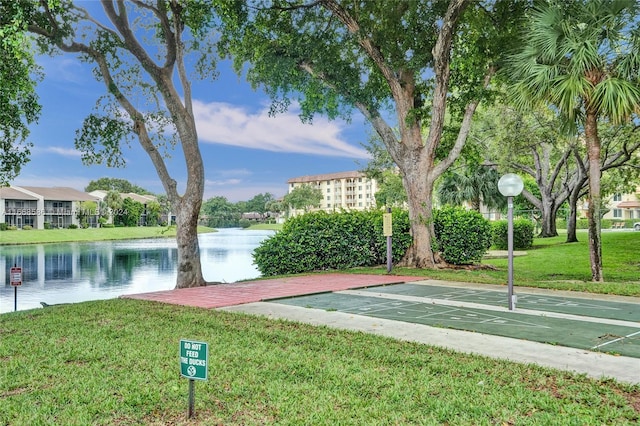 view of community featuring a water view and a yard