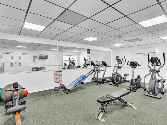 workout area featuring a drop ceiling and a wall mounted AC