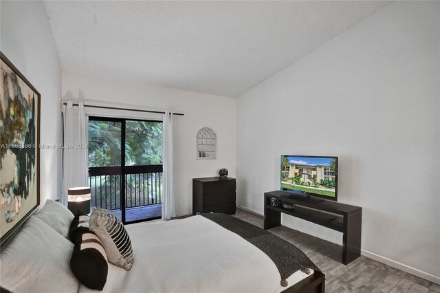 bedroom featuring hardwood / wood-style flooring, access to exterior, and a textured ceiling