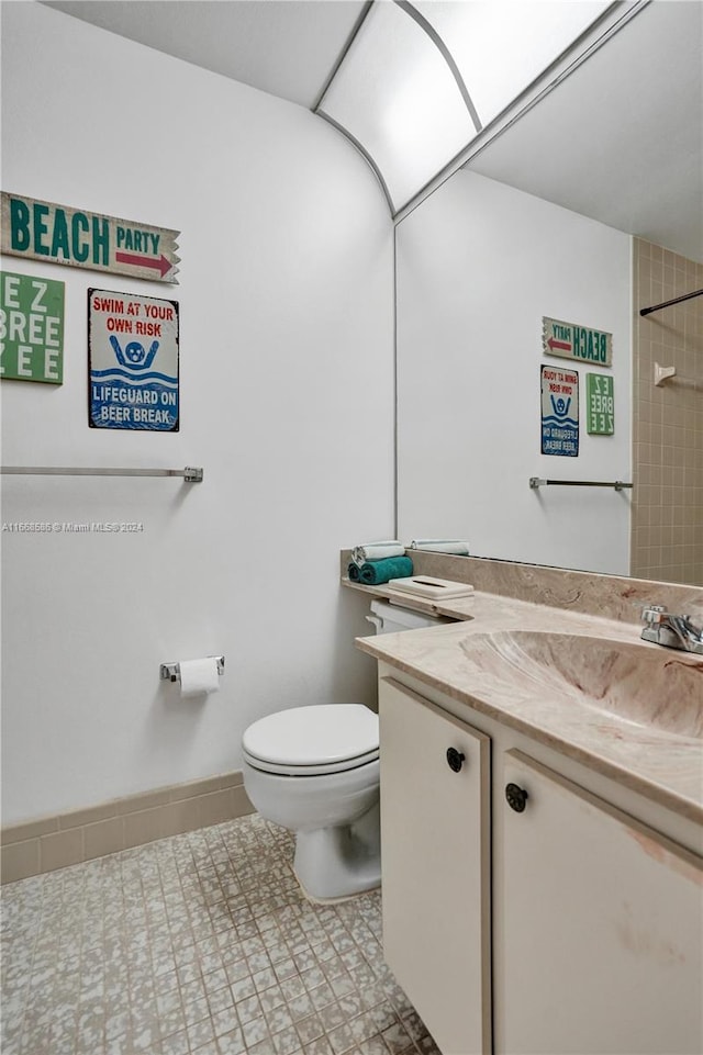 bathroom featuring tiled shower, vanity, toilet, and tile patterned floors