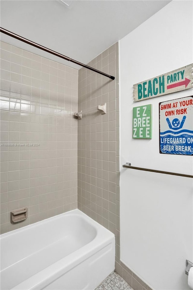 bathroom featuring tile patterned flooring and tiled shower / bath