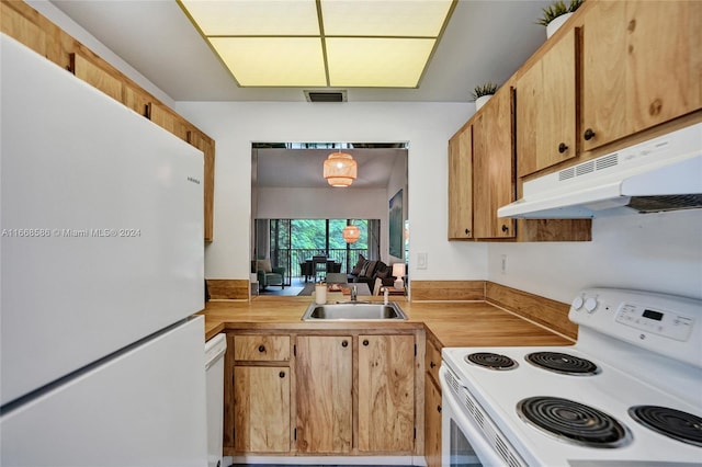 kitchen with white appliances, wooden counters, and sink