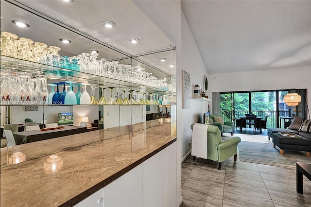 bar featuring white cabinets, lofted ceiling, and light tile patterned floors