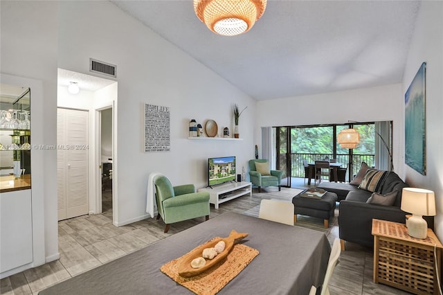 living room featuring wood-type flooring and high vaulted ceiling