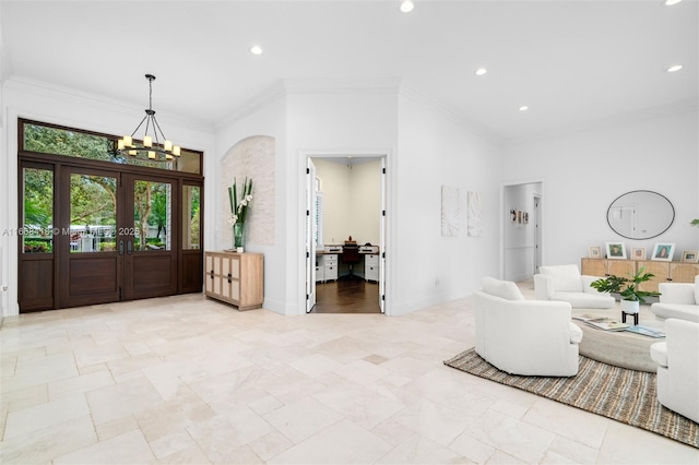 foyer entrance with crown molding and an inviting chandelier