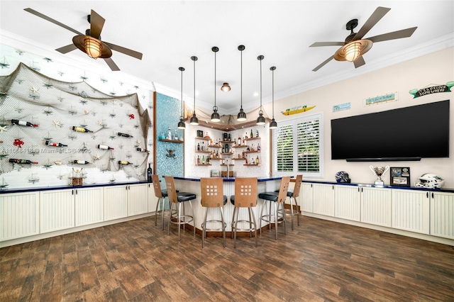 kitchen with hanging light fixtures, dark hardwood / wood-style flooring, a breakfast bar area, white cabinets, and ornamental molding