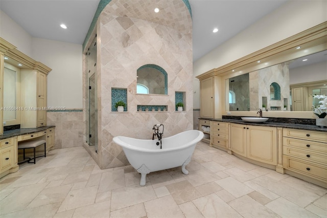 bathroom featuring shower with separate bathtub, vanity, and tile walls