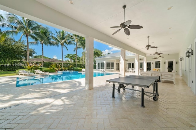 view of swimming pool featuring ceiling fan, a patio, and a hot tub