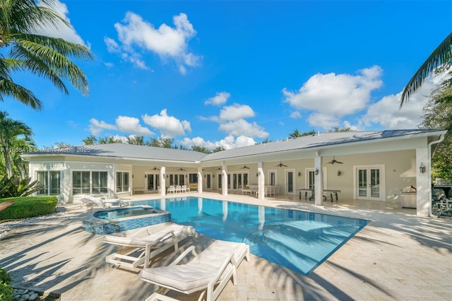 view of pool featuring french doors, ceiling fan, an in ground hot tub, a patio area, and exterior kitchen