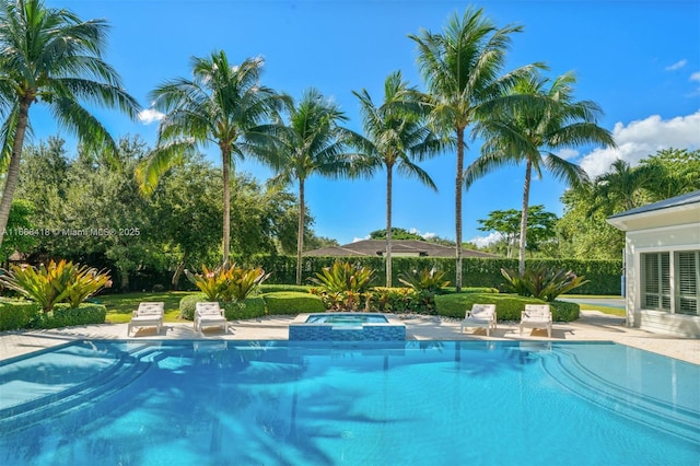 view of pool with a patio area and an in ground hot tub