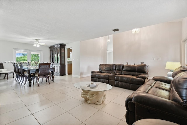 tiled living room featuring ceiling fan and a textured ceiling