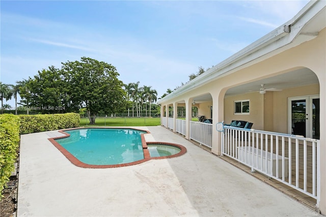 view of swimming pool with a patio, a lawn, ceiling fan, and an in ground hot tub