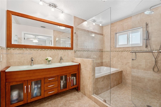 bathroom with tile walls, vanity, a textured ceiling, separate shower and tub, and ceiling fan