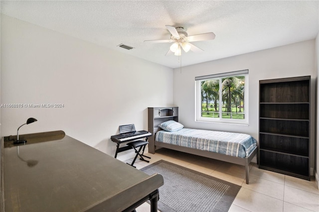 tiled bedroom featuring a textured ceiling and ceiling fan